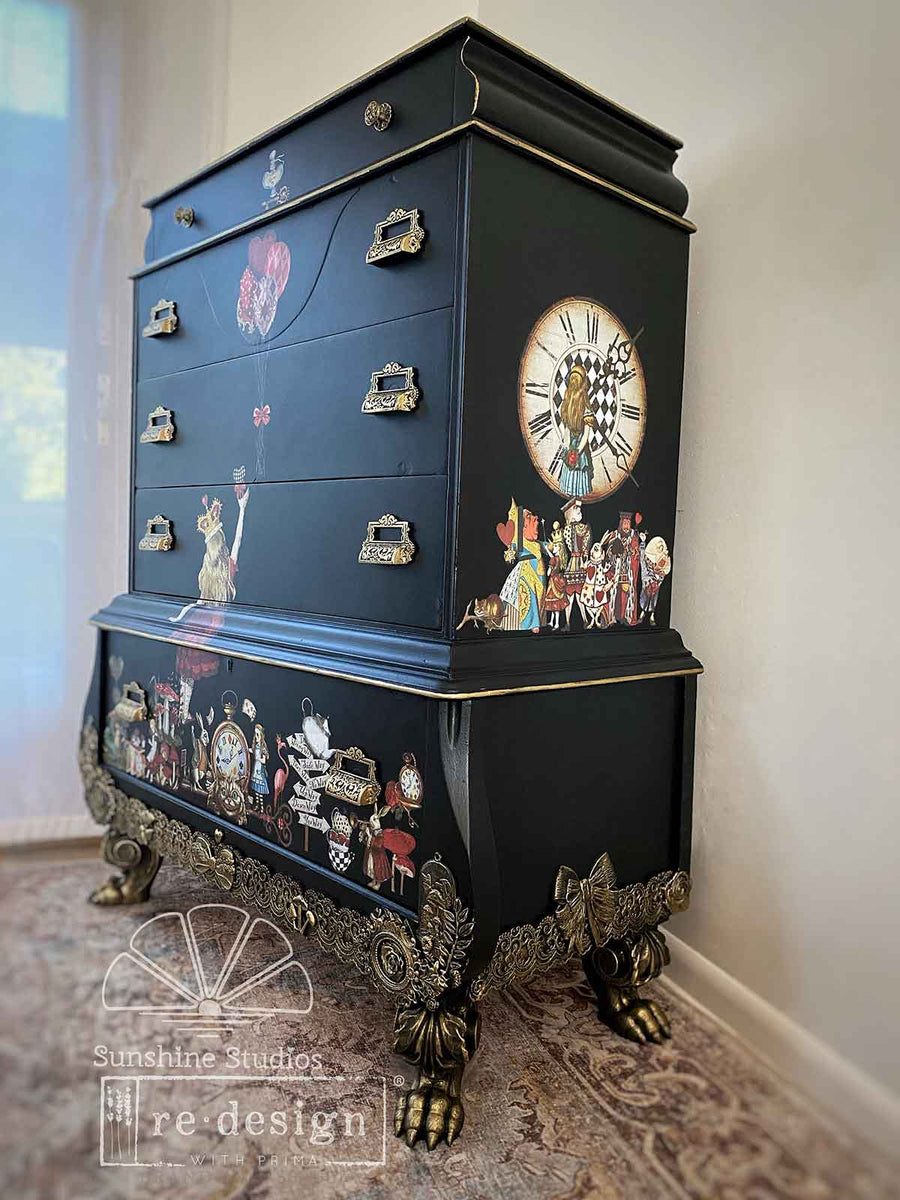 Side view of black dresser decorated with Alice in Wonderland transfers – includes oversized clock, Queen of Hearts, and teacup illustrations.