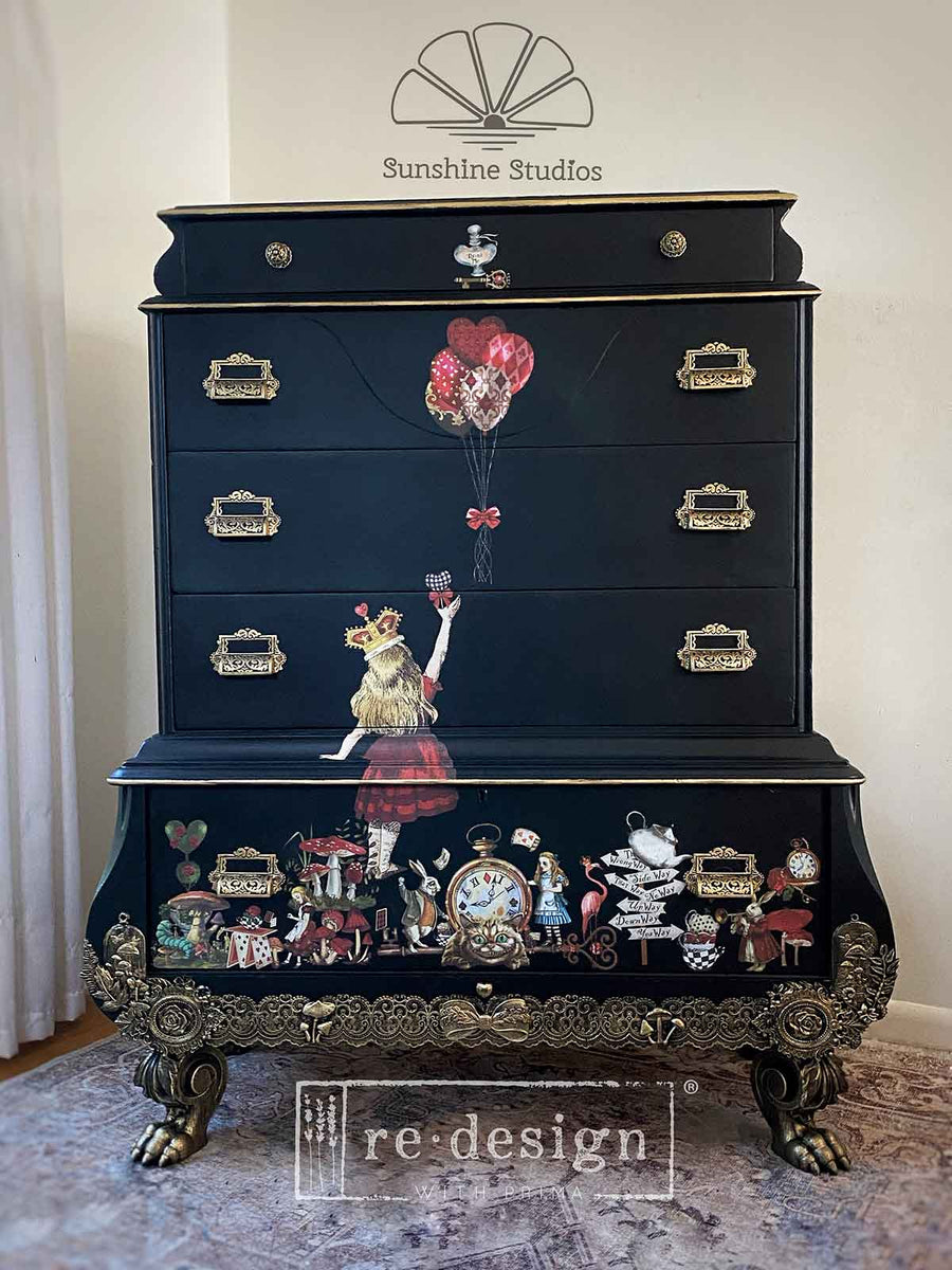 Black vintage dresser with ornate feet, decorated with Alice in Wonderland transfers – Sunshine Studios project featuring Alice, Mad Hatter, and fantasy details.

