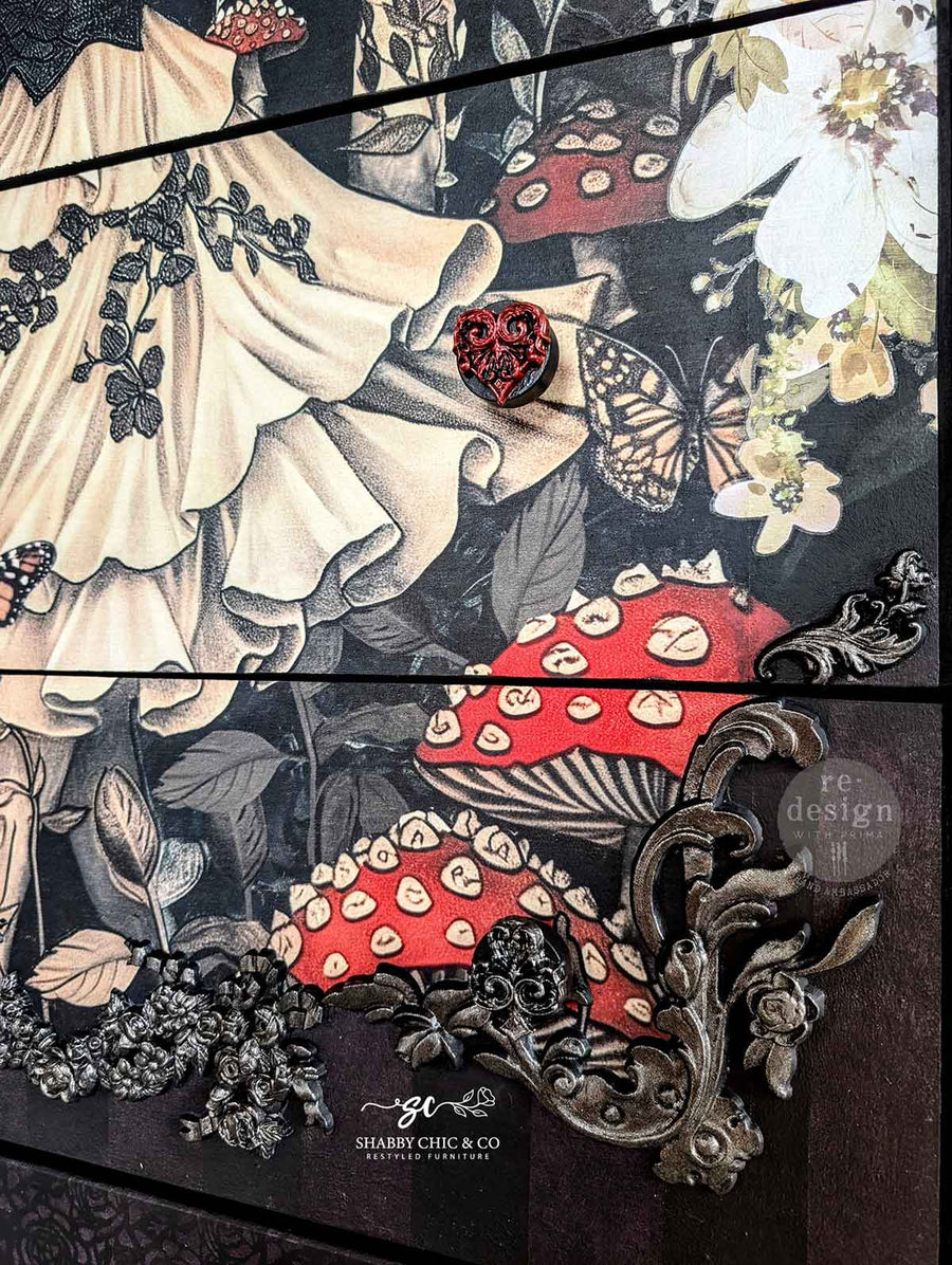Close-up of Enigmatic Realm decoupage applied to drawer fronts, highlighting butterfly, mushroom, and ornate hardware detail.