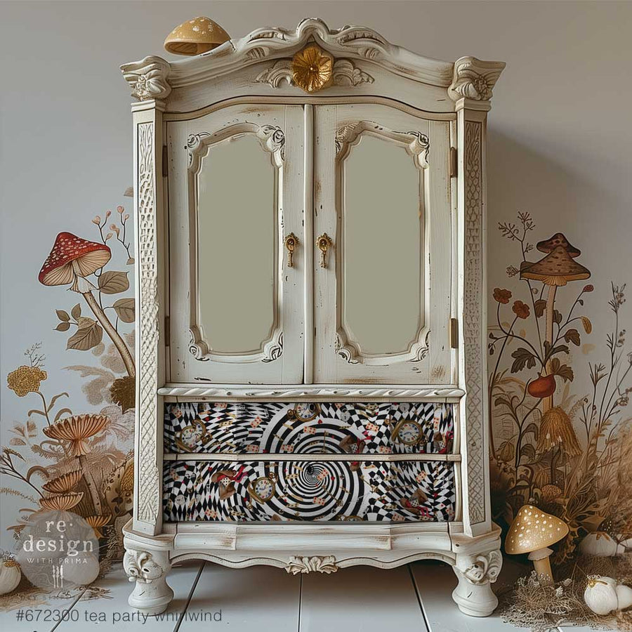 A vintage white armoire with distressed finish, decorated with the Tea Party Whirlwind decoupage paper on the lower drawers. Wonderland mushrooms flank the cabinet